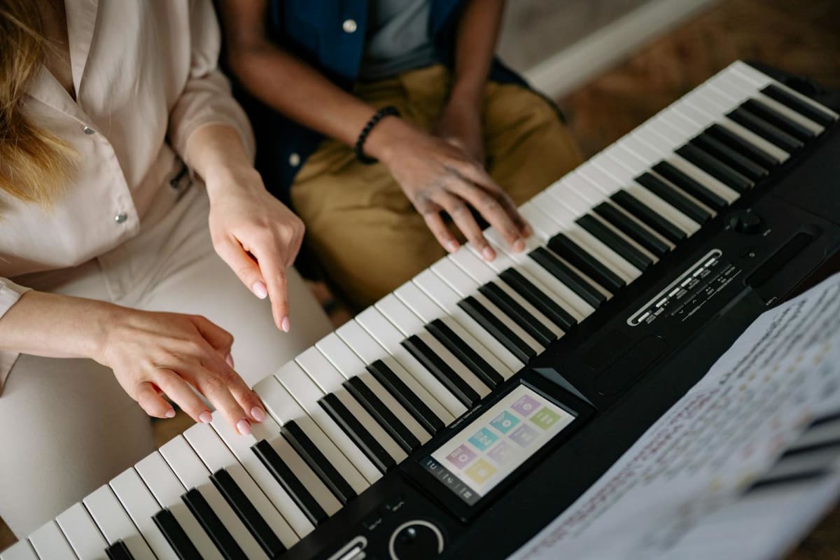 Teacher and student hands at the keyboard during a piano lesson