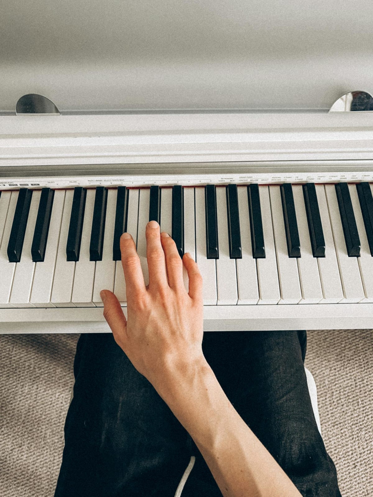 Close-up of a hand playing digital piano keys