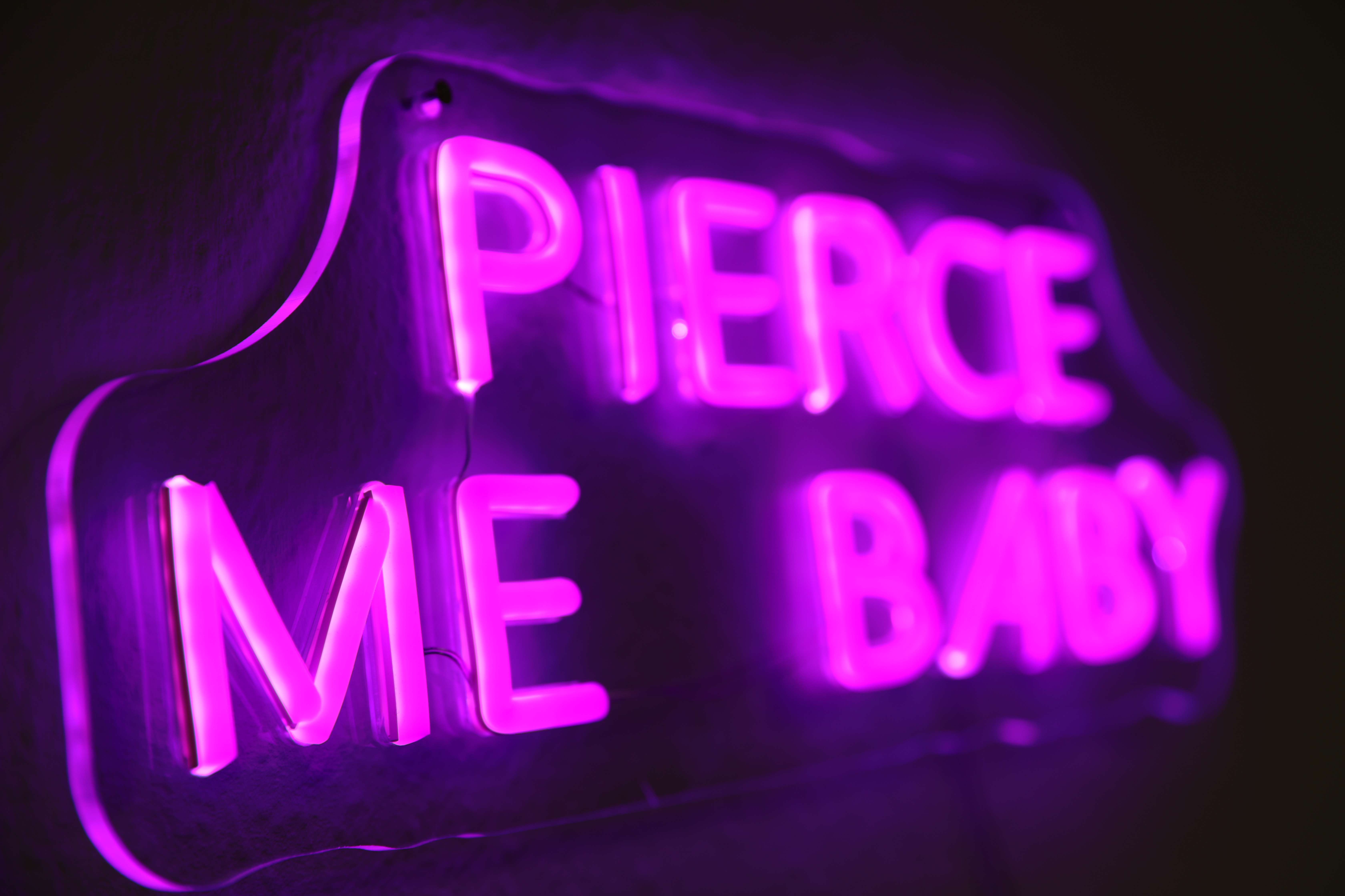 Piercing Me Baby Neon sign inside of Anker Tattoo & Piercing Studio in Freiburg