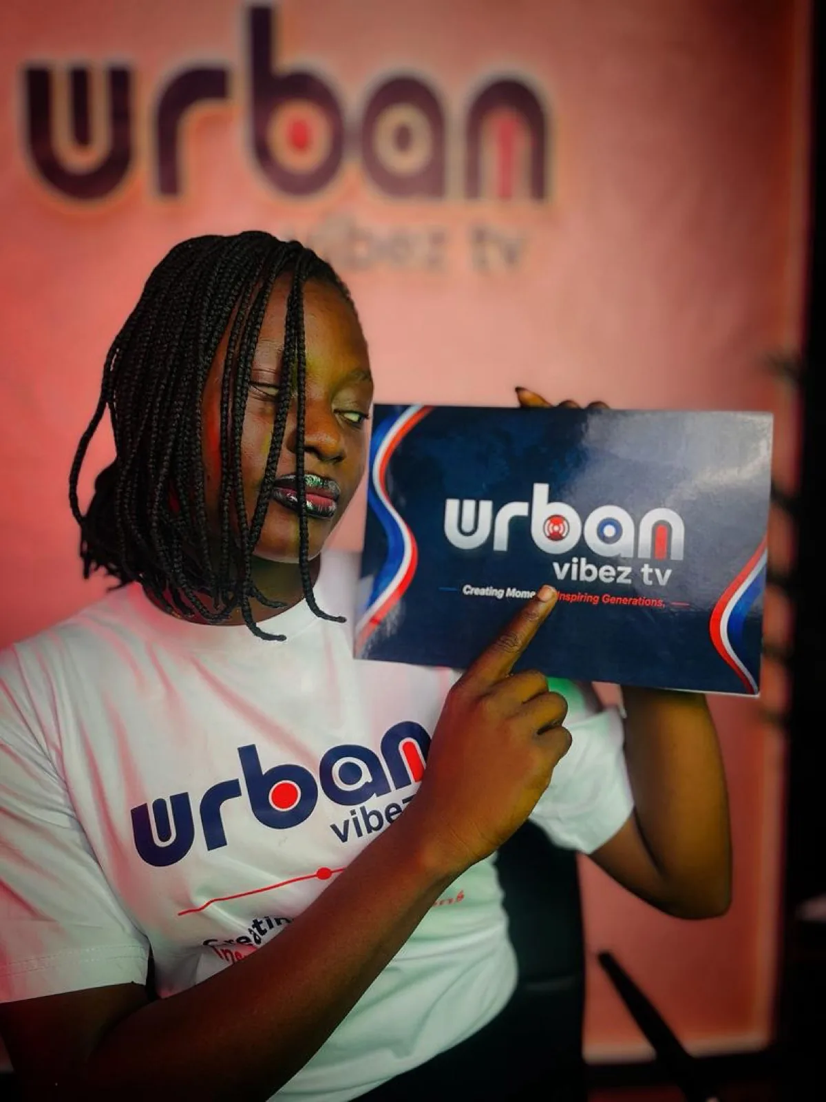 Host pointing at the Urban Vibez TV logo card