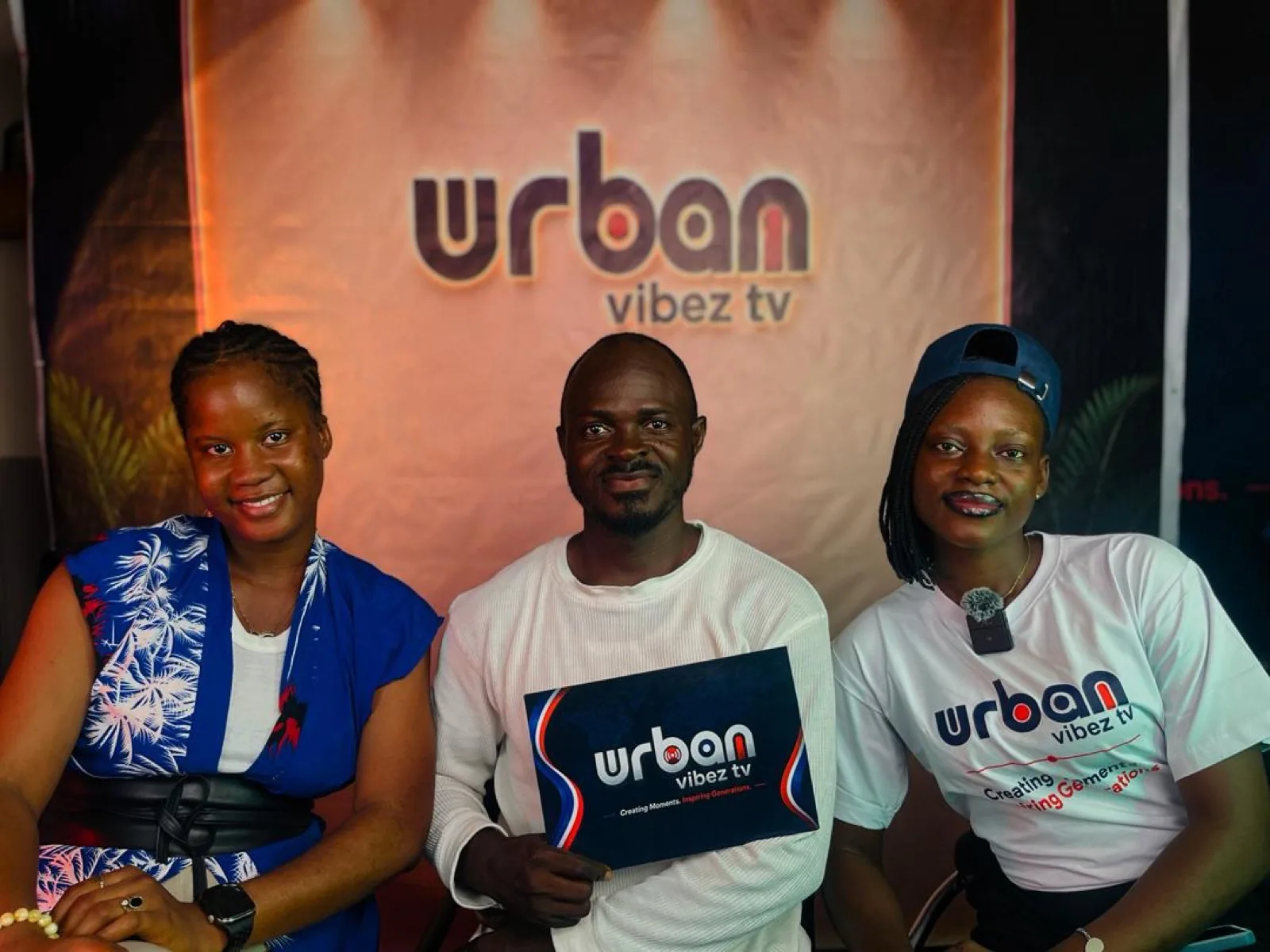 Three hosts with the Urban Vibez TV logo card