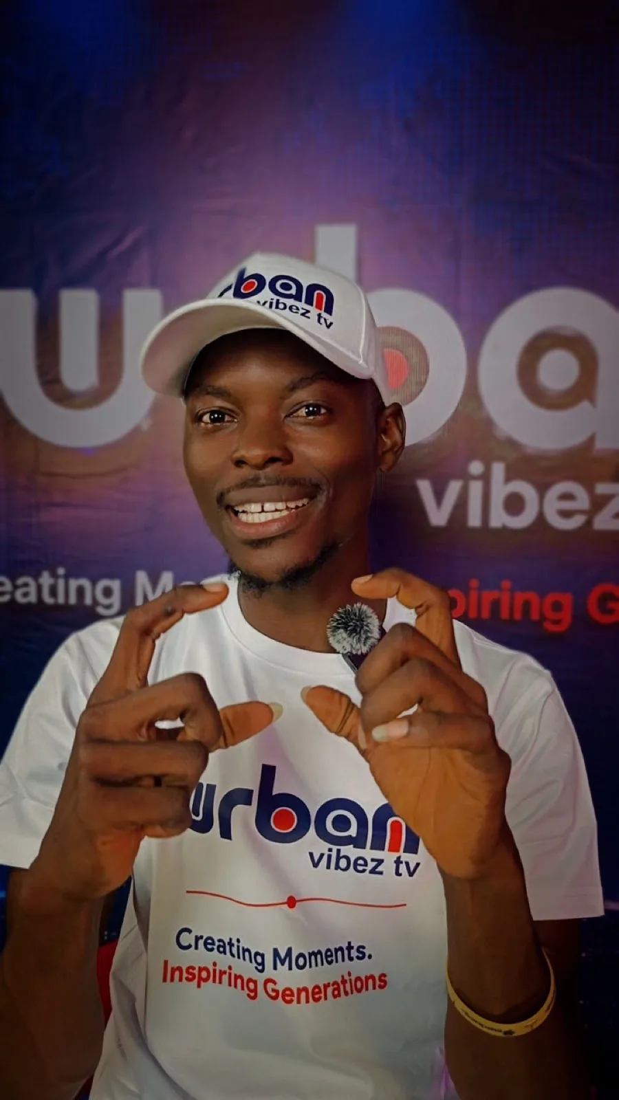 Host in a branded cap pointing to camera