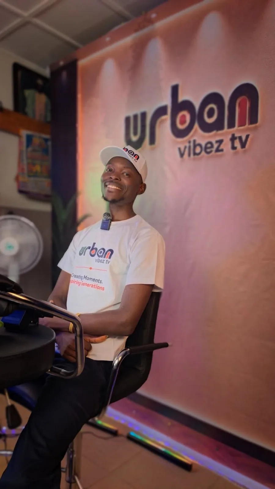 Host in a branded cap and tee, seated in the studio