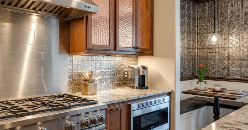 Kitchen with stainless steel appliances, granite counters, metallic backsplash, and cozy breakfast nook with pendant light