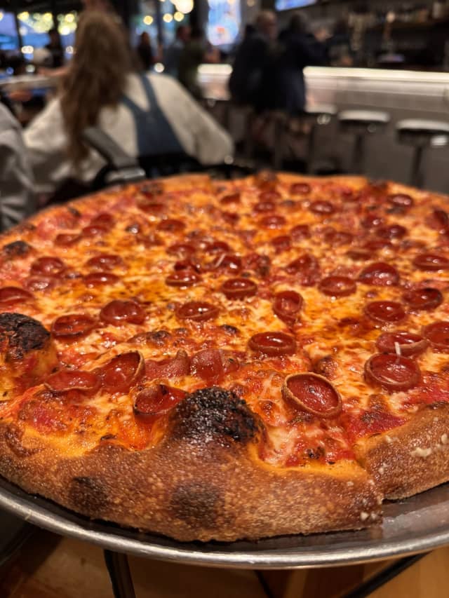 Hot Honey Pie with cupped pepperoni, chili flakes, and hot honey drizzle on a metal tray at AJ's Pizza Joint in Winter Garden Florida