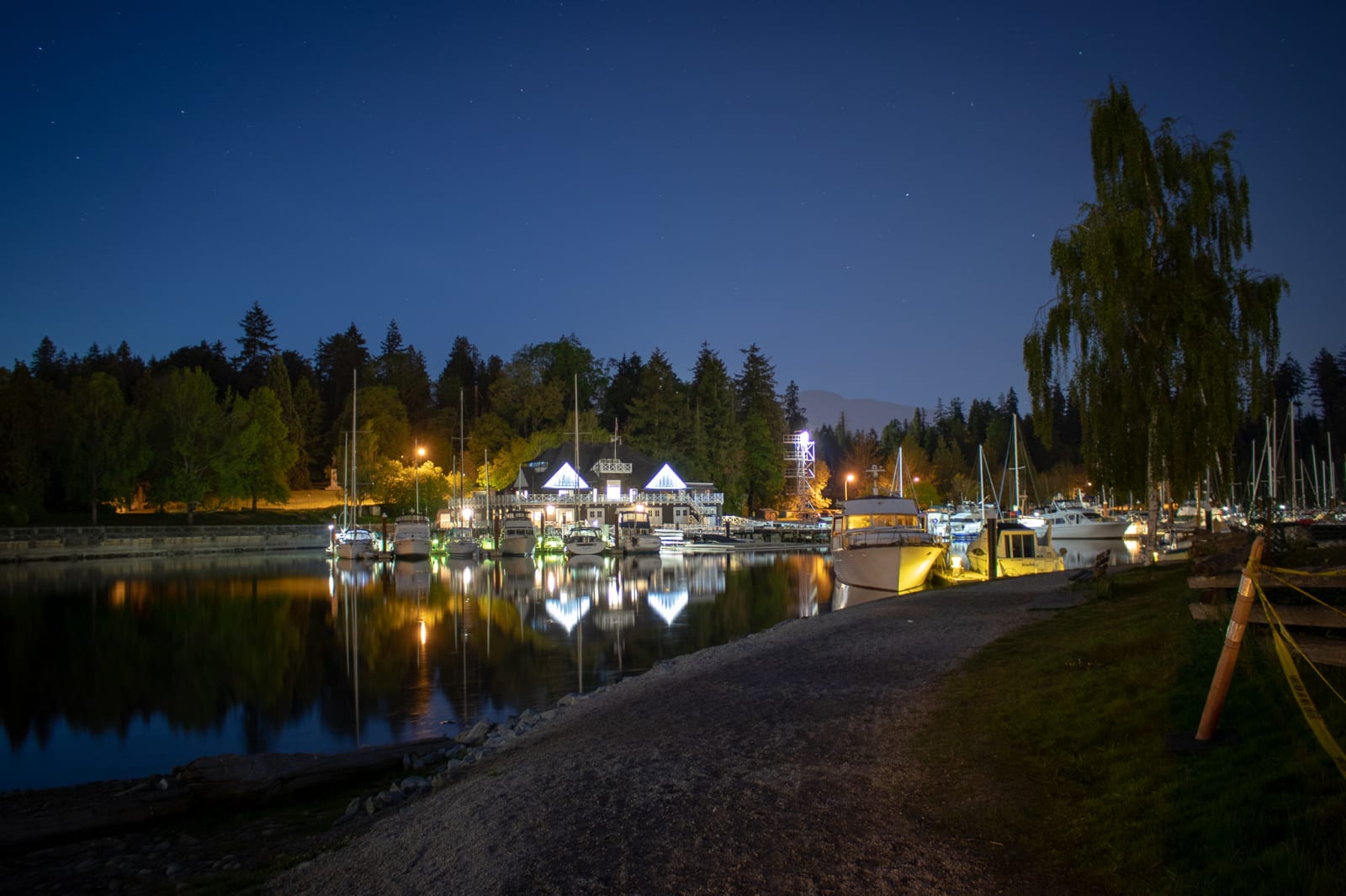 A marina at blue hour, boats reflected on still water