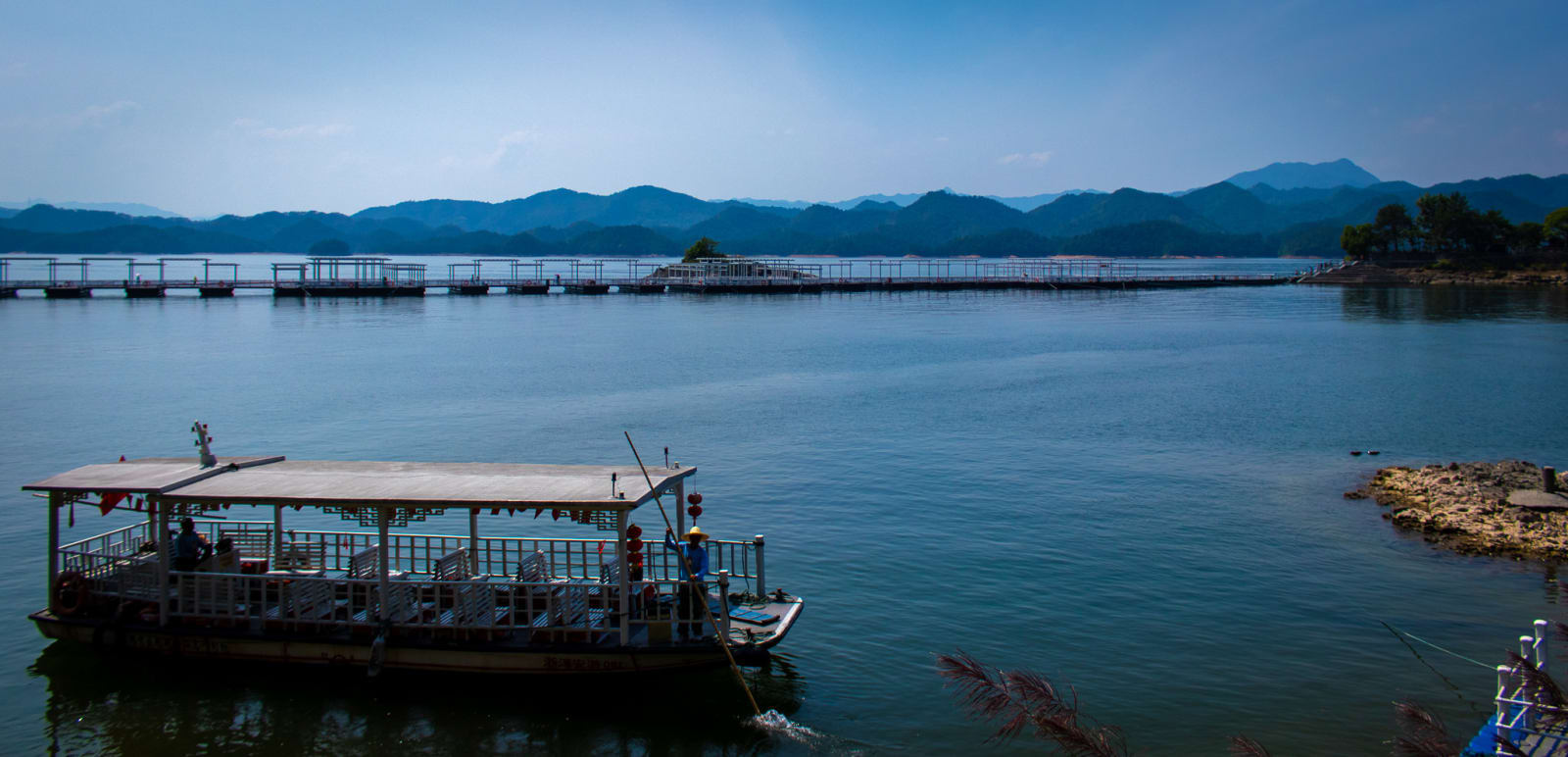 A boat on a calm lake dotted with islands