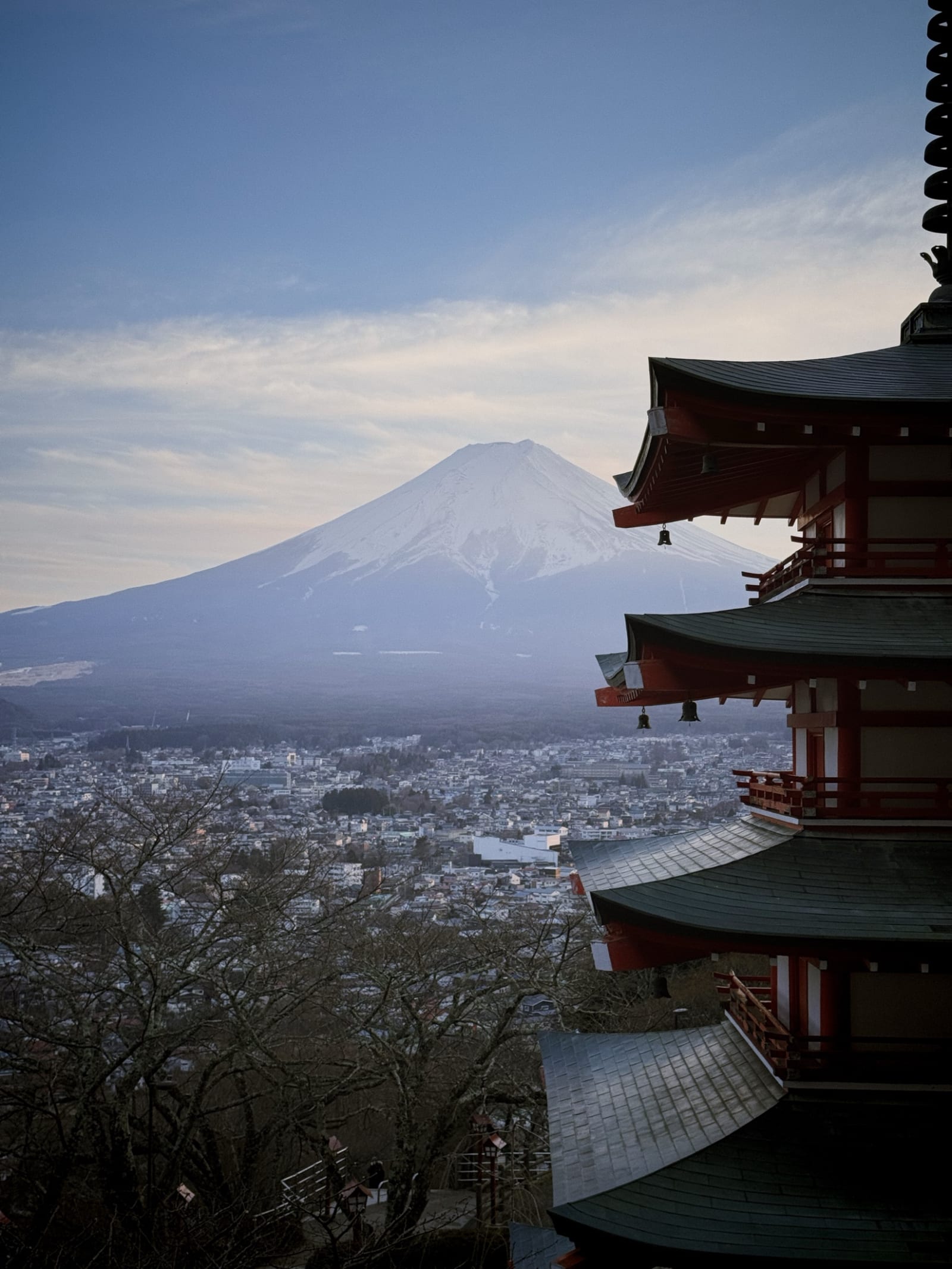 A five-story pagoda with Mount Fuji rising behind it