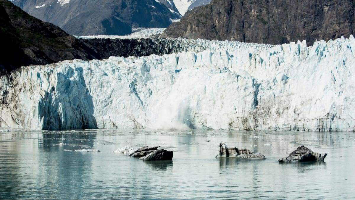 View of Mendenhall glacier from the sea with a view of the mountains in the background.