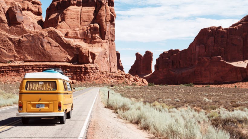 A van taking a roadtrip through the desert of Nevada.
