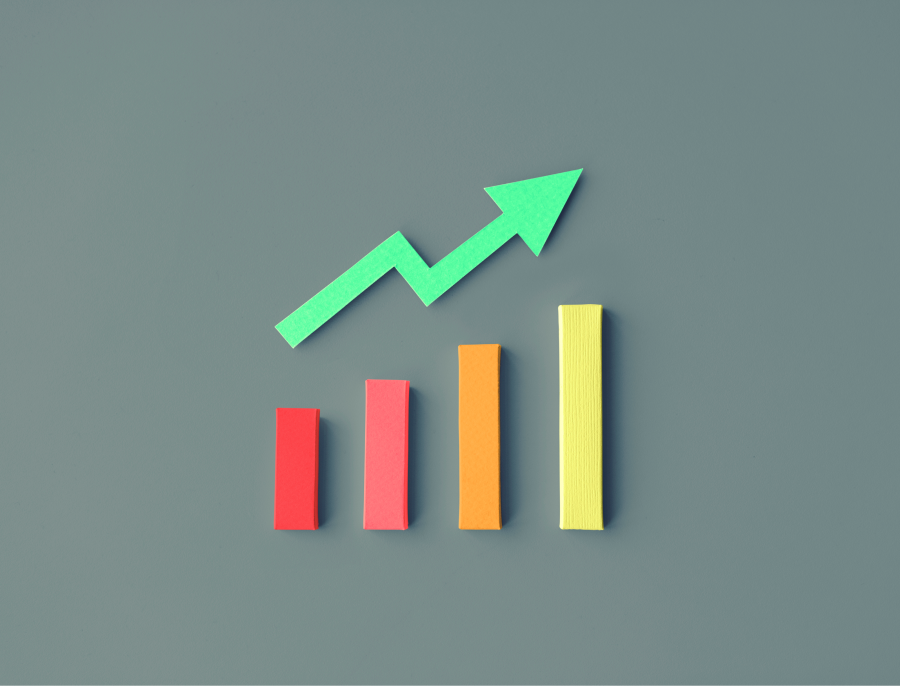 Four paper craft bars rising from left to right beneath a green upward arrow