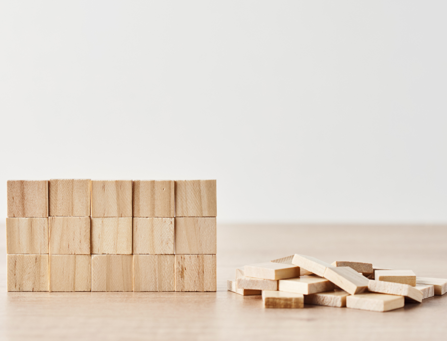 Wooden blocks stacked into a neat wall on the left, with a loose pile of unstacked blocks lying beside it