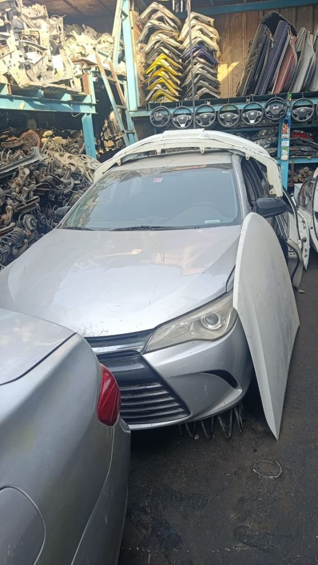 Silver Toyota Camry sedan front end for parts — bumper, grille, headlights and dented hood, Sharjah market