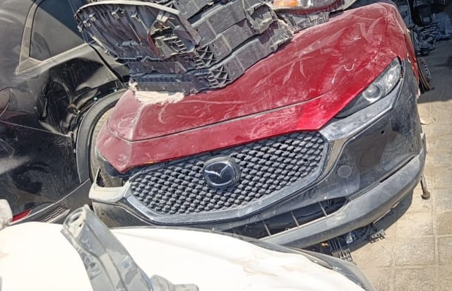 Dark red Mazda CX-30 SUV front halfcut — hood, mesh grille, bumper and headlight, Sharjah market