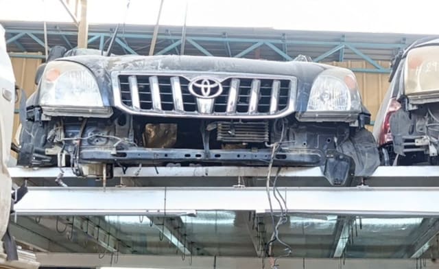 Dark Toyota Land Cruiser Prado front halfcut — chrome grille, headlights and radiator support, Sharjah market