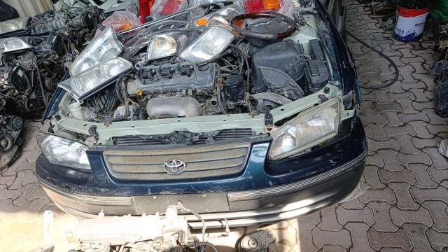 Dark green Toyota Camry front halfcut — bumper, grille, headlights and engine bay, Sharjah market