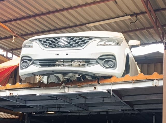 White Suzuki Baleno hatchback front cut — bumper, grille and headlights, Sharjah market