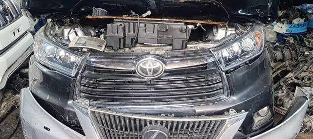 Black Toyota Highlander SUV front cut — bumper, grille, headlights and open engine bay, Sharjah market