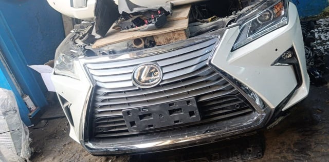 White Lexus RX SUV front halfcut — spindle grille, bumper and headlight, Sharjah market