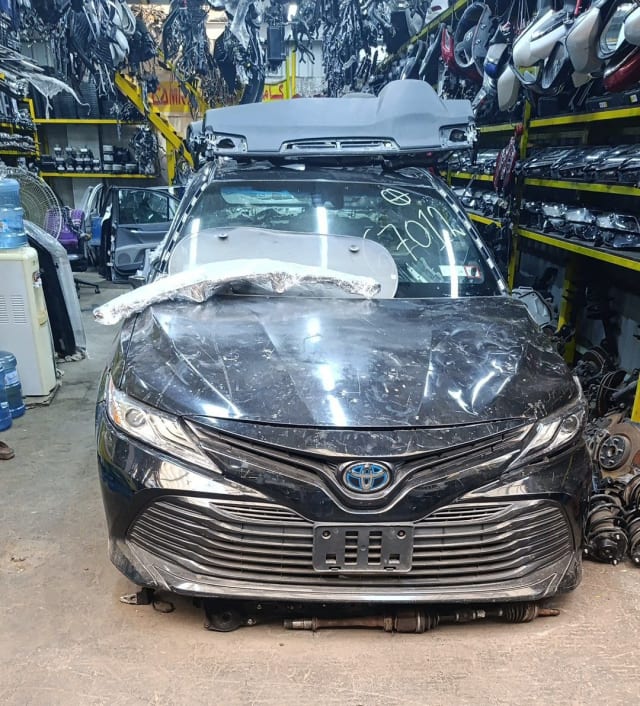 Black Toyota Camry sedan halfcut front — hood, chrome grille, bumper and headlights, Sharjah market