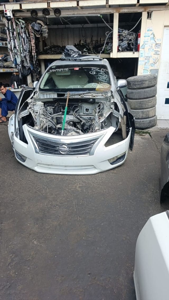 White Nissan Altima sedan front halfcut — bumper, grille, headlights and exposed engine bay, Sharjah market