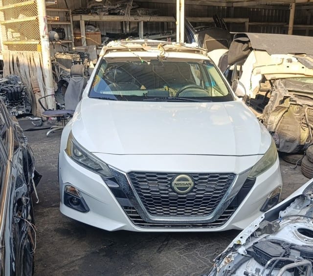 White Nissan Altima sedan front cut — bumper, grille, headlights and hood, Sharjah market