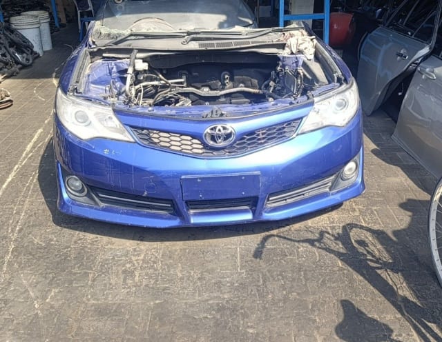 Blue Toyota Camry sedan front halfcut — bumper, grille, headlights and exposed engine bay, Sharjah market