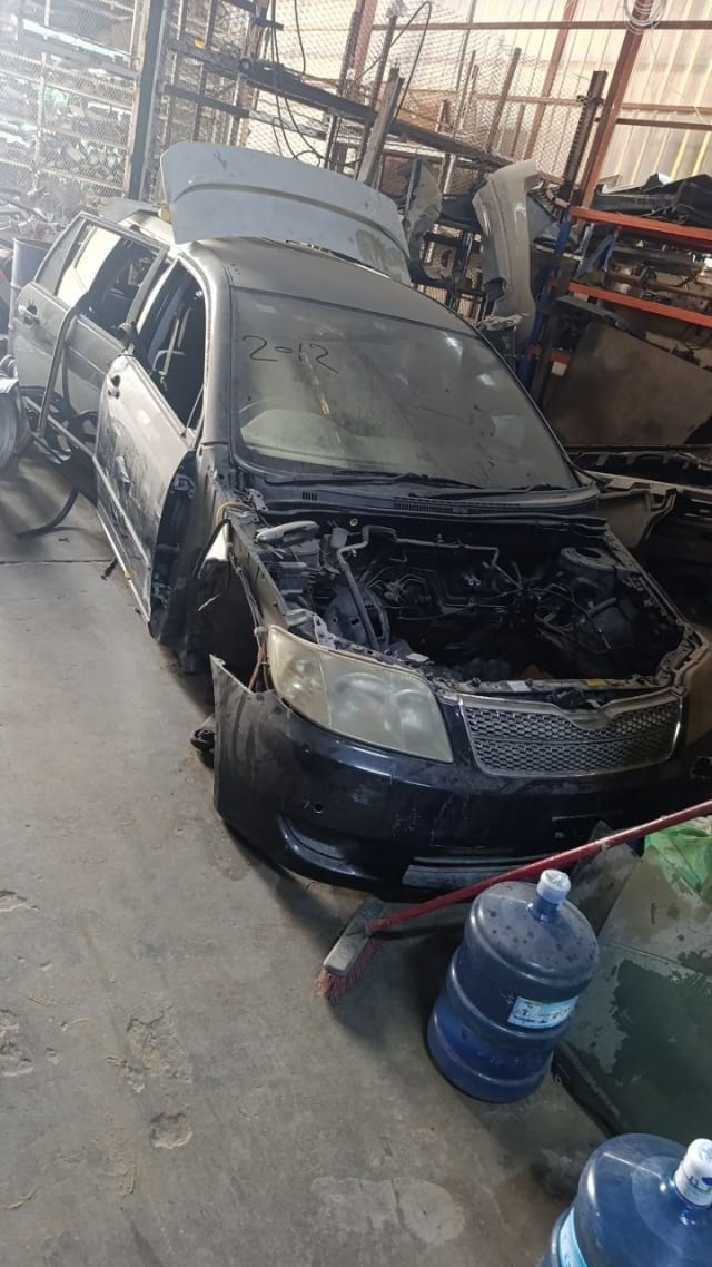 Black Toyota Corolla front halfcut — bumper, grille, headlights and exposed engine bay, Sharjah market