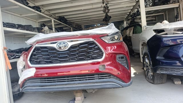 Red Toyota Highlander SUV front cut — bumper, chrome grille and headlights, Sharjah market