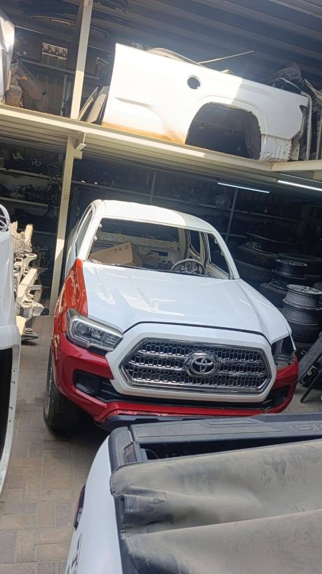 White and red Toyota Tacoma pickup halfcut — front cut with grille, headlights and hood, Sharjah market