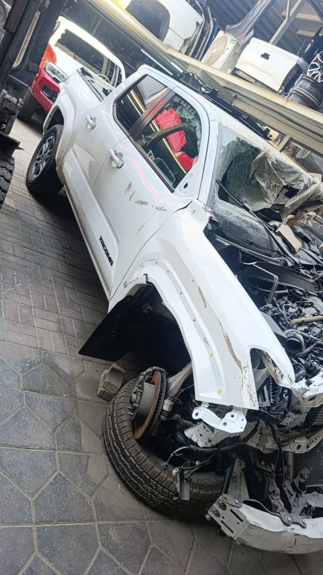 White Toyota Tacoma pickup halfcut — cab, doors, fender and exposed engine bay, Sharjah market