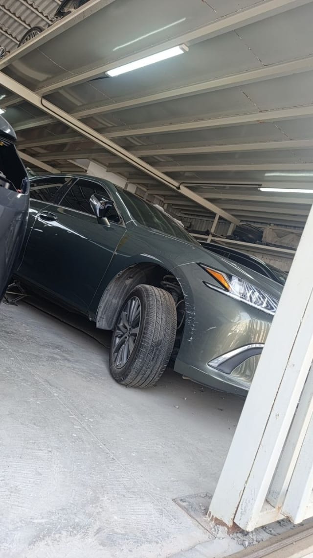 Dark green Lexus ES sedan front three-quarter — bumper, headlight, fender and alloy wheel, Sharjah market