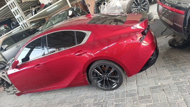 Red Mazda3 hatchback halfcut rear side — quarter panel, door, tail light and black alloy wheel, Sharjah market