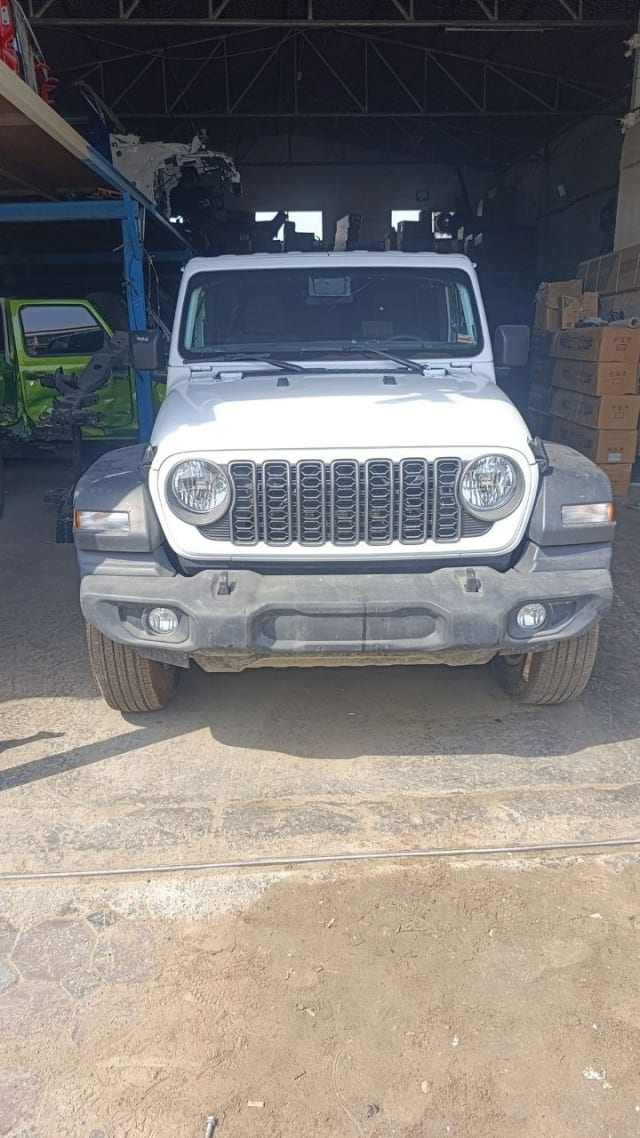 White Jeep Wrangler SUV front — bumper, seven-slot grille, headlights and hood, Sharjah market