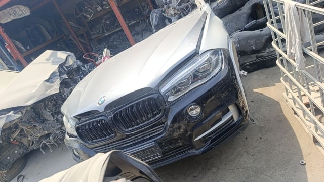 Silver and black BMW X5 SUV front halfcut — bumper, kidney grille and headlights, Sharjah market