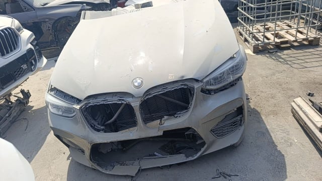 White BMW X3 SUV front halfcut — hood, headlights, kidney grille and damaged bumper, Sharjah market