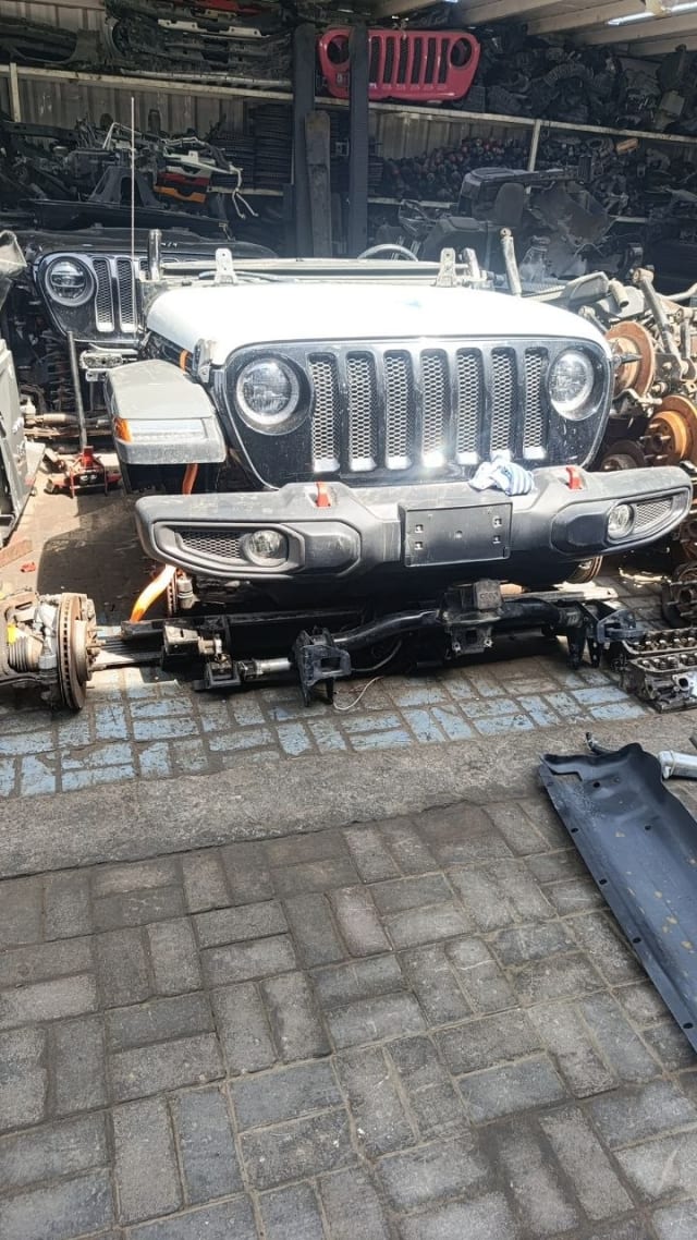 White Jeep Wrangler front halfcut — grille, headlights, bumper and front axle, Sharjah market