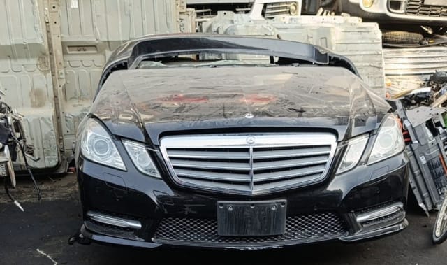 Black Mercedes-Benz E-Class sedan front halfcut — bumper, chrome grille and headlights, Sharjah market