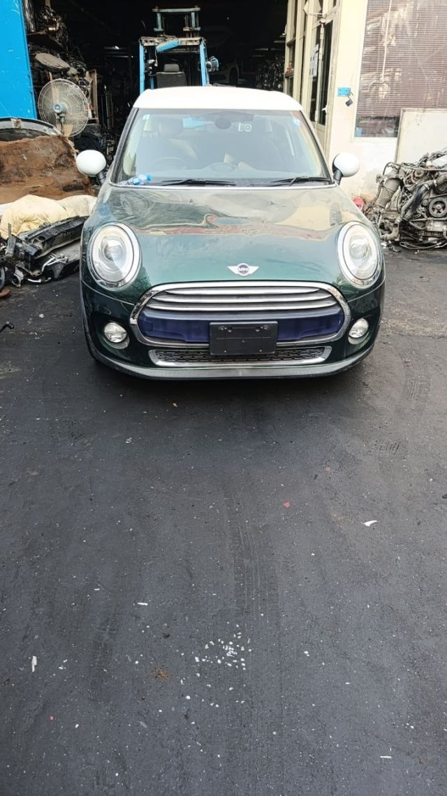 Dark green MINI Cooper hatchback front — bumper, grille, headlights and white roof, Sharjah market