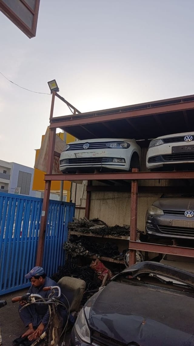 White Volkswagen Passat front halfcuts racked with bumpers, grilles and headlights, Sharjah market