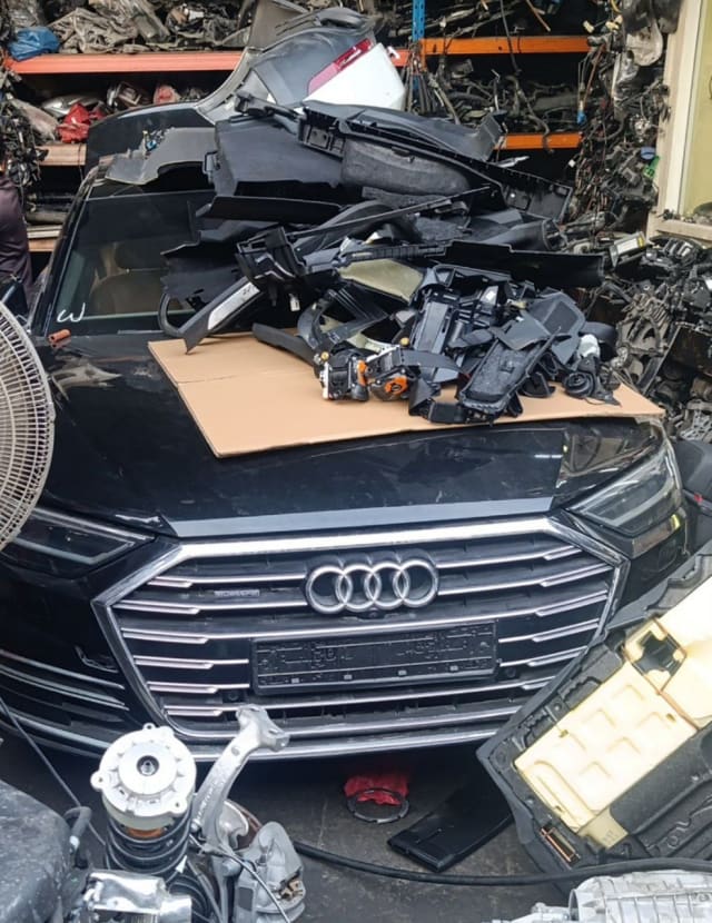 Black Audi A8 front halfcut — grille, hood and windshield with stacked trim parts, Sharjah market