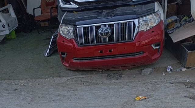 Red Toyota Land Cruiser Prado front cut — bumper, chrome grille and headlights, Sharjah market