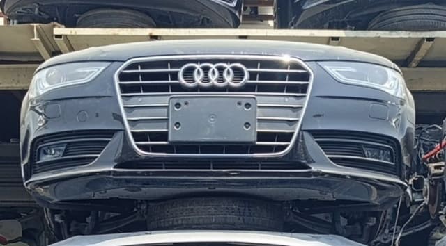 Black Audi A6 sedan front cut — bumper, chrome grille and headlights, Sharjah market
