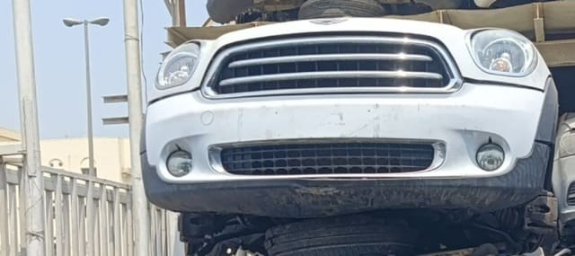 White MINI Cooper hatchback front cut — grille, round headlights and bumper with fog lights, Sharjah market
