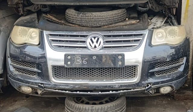 Dark grey Volkswagen Touareg front halfcut — bumper, chrome grille, headlights and fog lights, Sharjah market