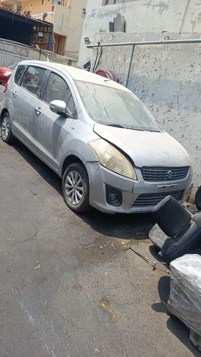 Silver Suzuki Ertiga MPV front three-quarter — bumper, grille, headlights and wheels, Sharjah market