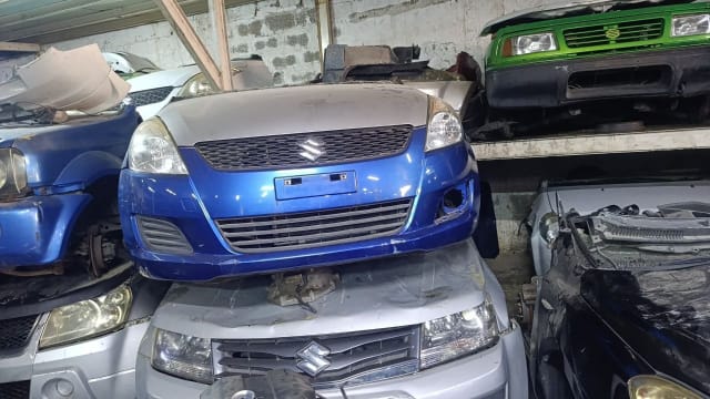 Blue Suzuki Swift hatchback front cut — bumper, grille and headlights, Sharjah market