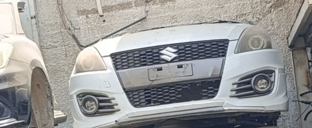 White Suzuki Swift Sport front cut — bumper, honeycomb grille, headlights and fog lamps, Sharjah market