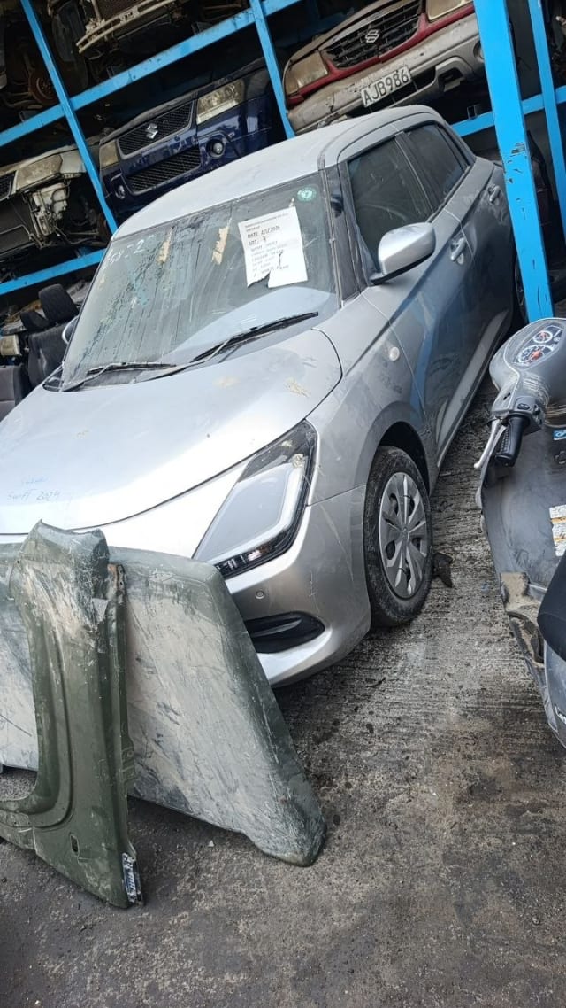 Silver Suzuki Swift hatchback car for parts — front bumper, headlight, hood and alloy wheel, Sharjah market