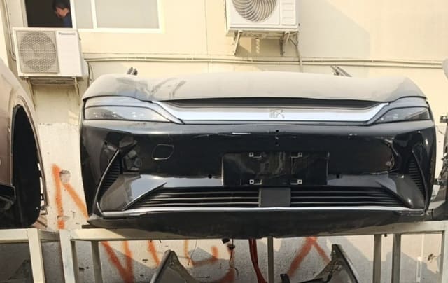 Black BYD Han sedan front cut — bumper, slim headlights and chrome grille trim, Sharjah market